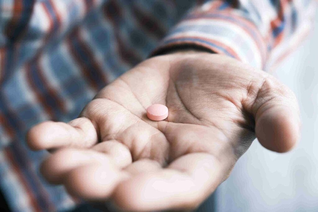 Une main avec une pilule pour suggérer les contre-indications du CBG avec certains médicaments