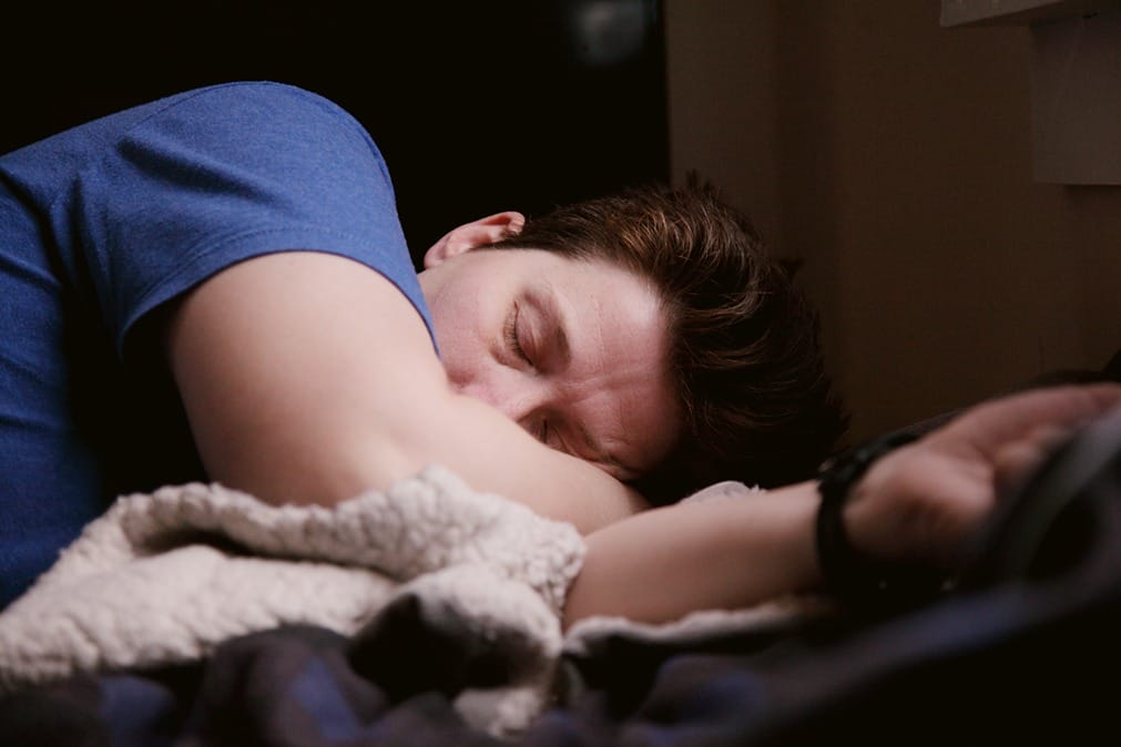 Un homme dormant dans un lit symbolisant les effets secondaires du CBD