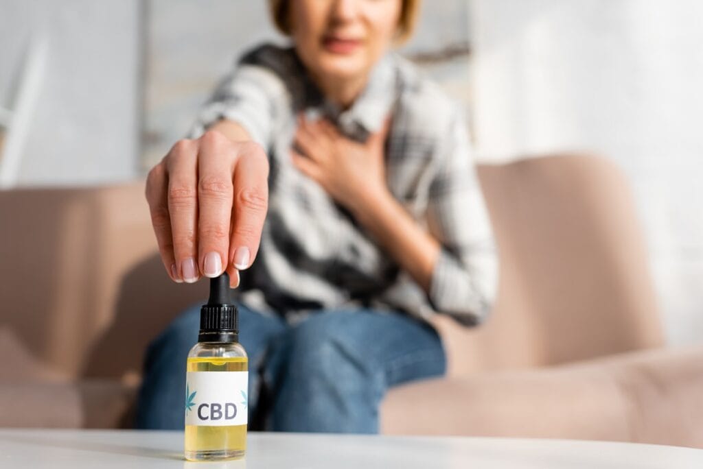 Une femme prenant de l'huile de CBD qui symbolise les effets du CBD sur le corps humain