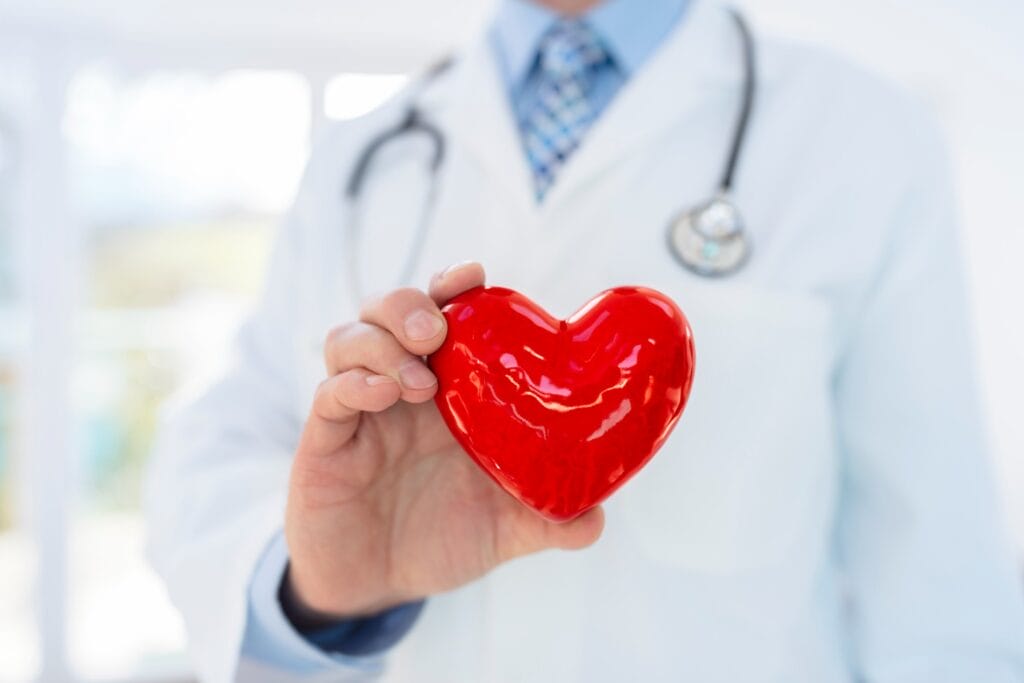A doctor holding a heart in his hand as a symbol of cardiovascular health