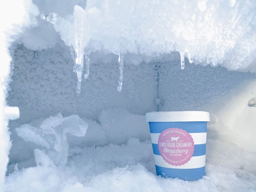 Ein Gefrierschrank voller Eiskristalle mit einer Schale Sorbet darin