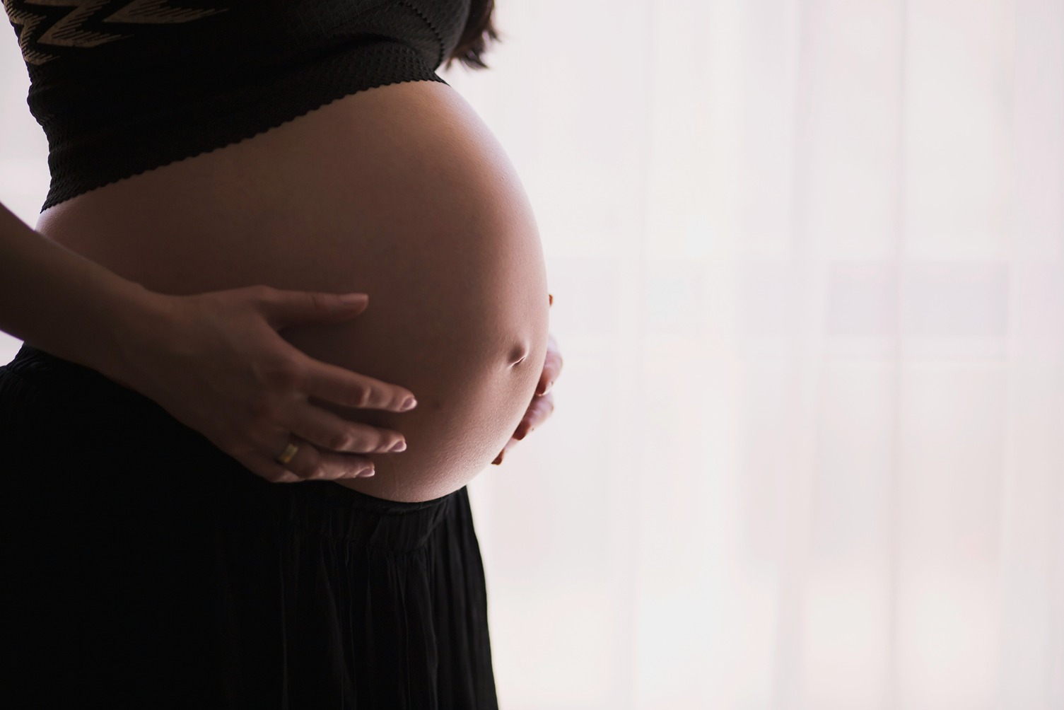 Une femme enceinte protège son ventre, illustrant les précautions CBD nécessaires pendant la grossesse