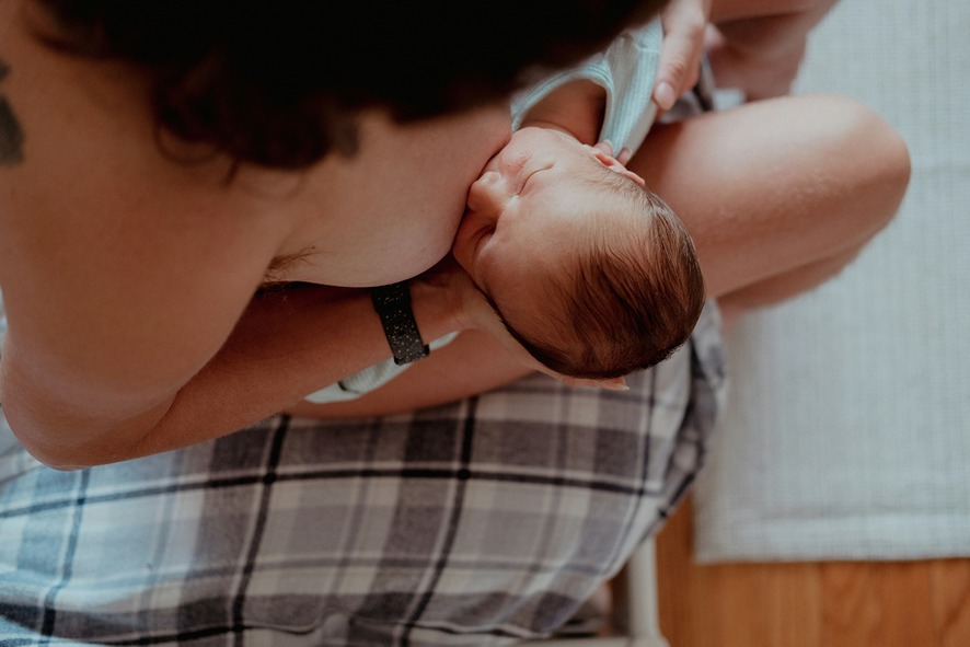 Stillende Mutter hält Baby, CBD Risiken in Muttermilch