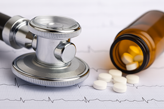 Stéthoscope et comprimés sur ECG, illustrant les interactions du CBD avec les médicaments cardiovasculaires